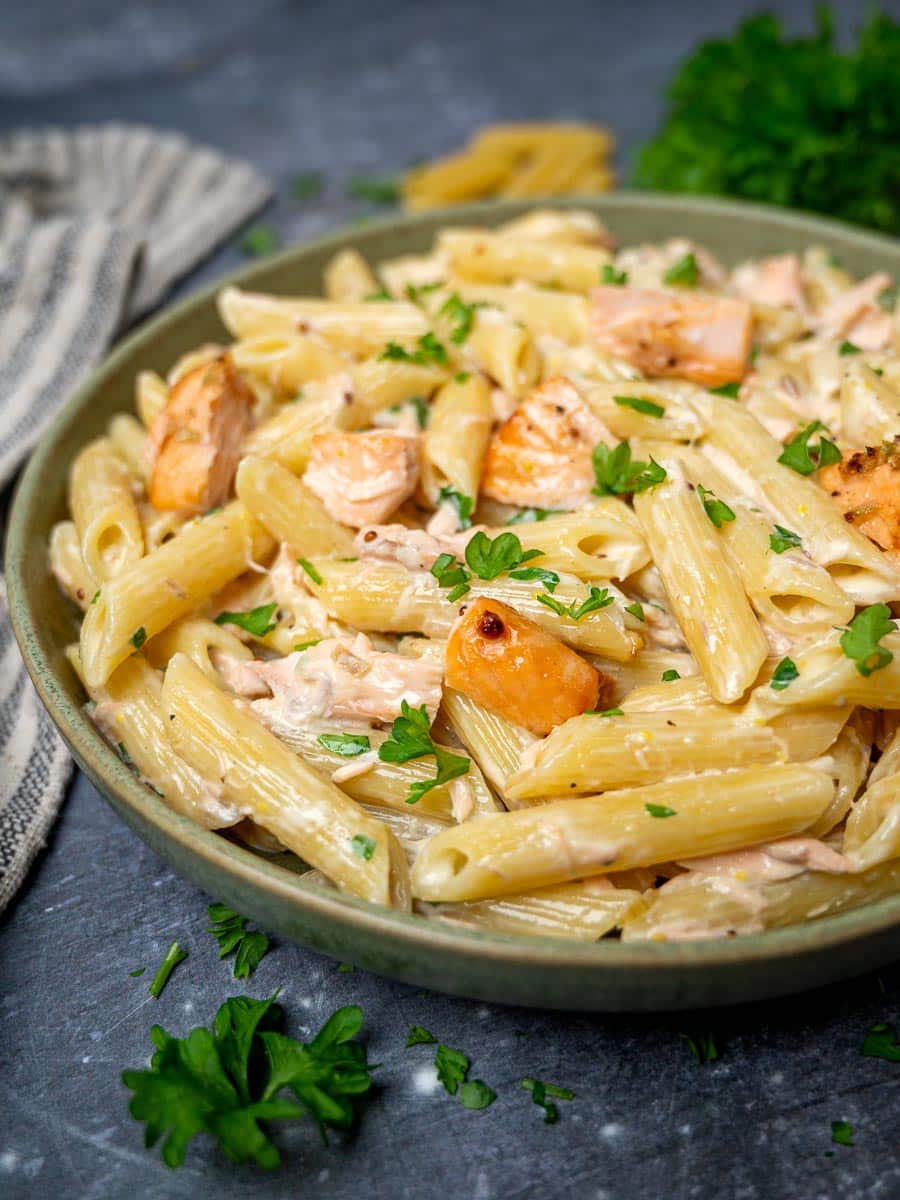 A bowl of creamy pasta with parsley on top