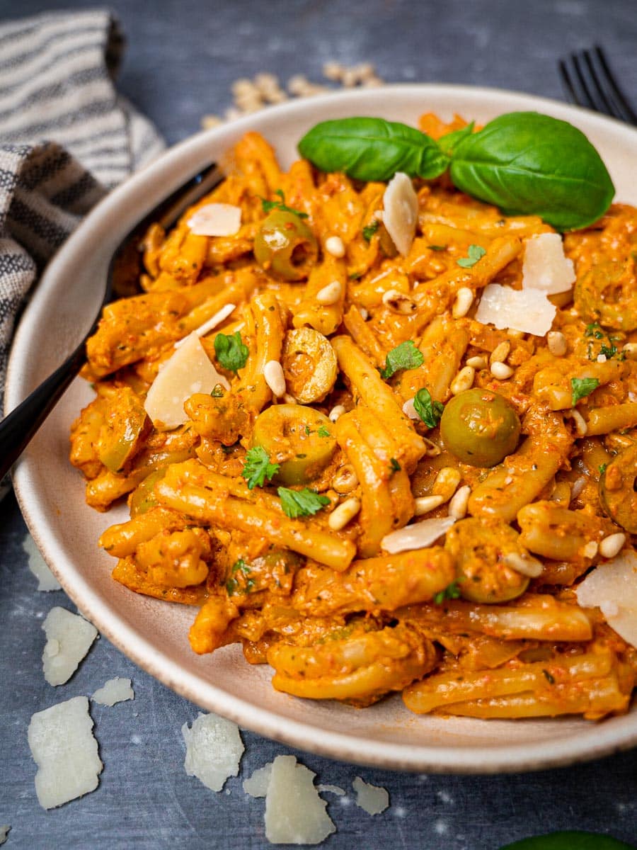 a plate of red pesto pasta