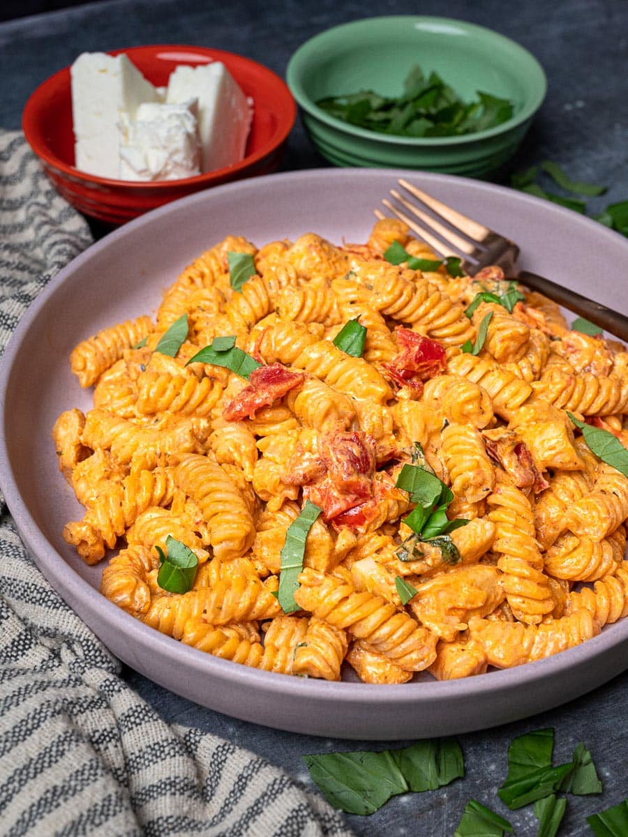 A bowl of chicken feta pasta with basil