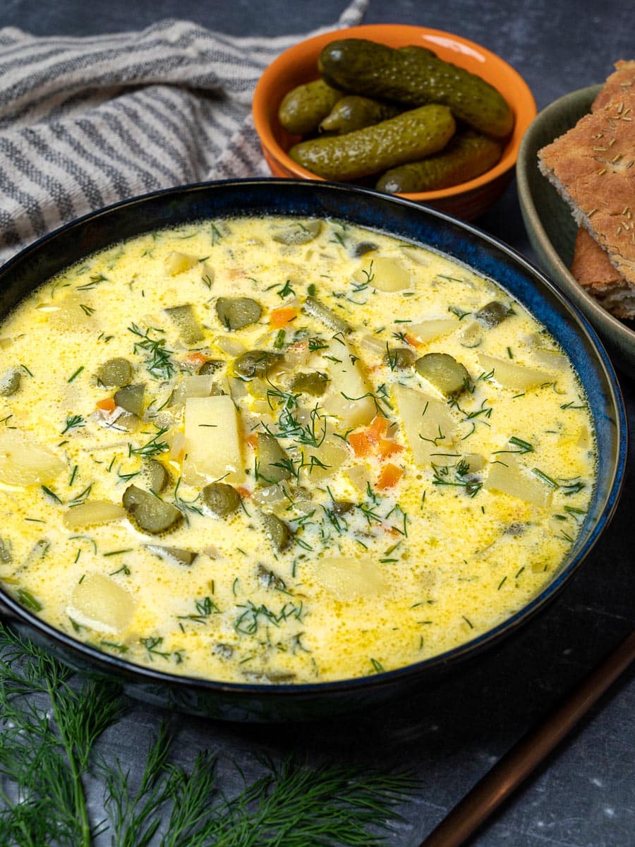 A bowl of zupa ogórkowa with pickles and potatoes