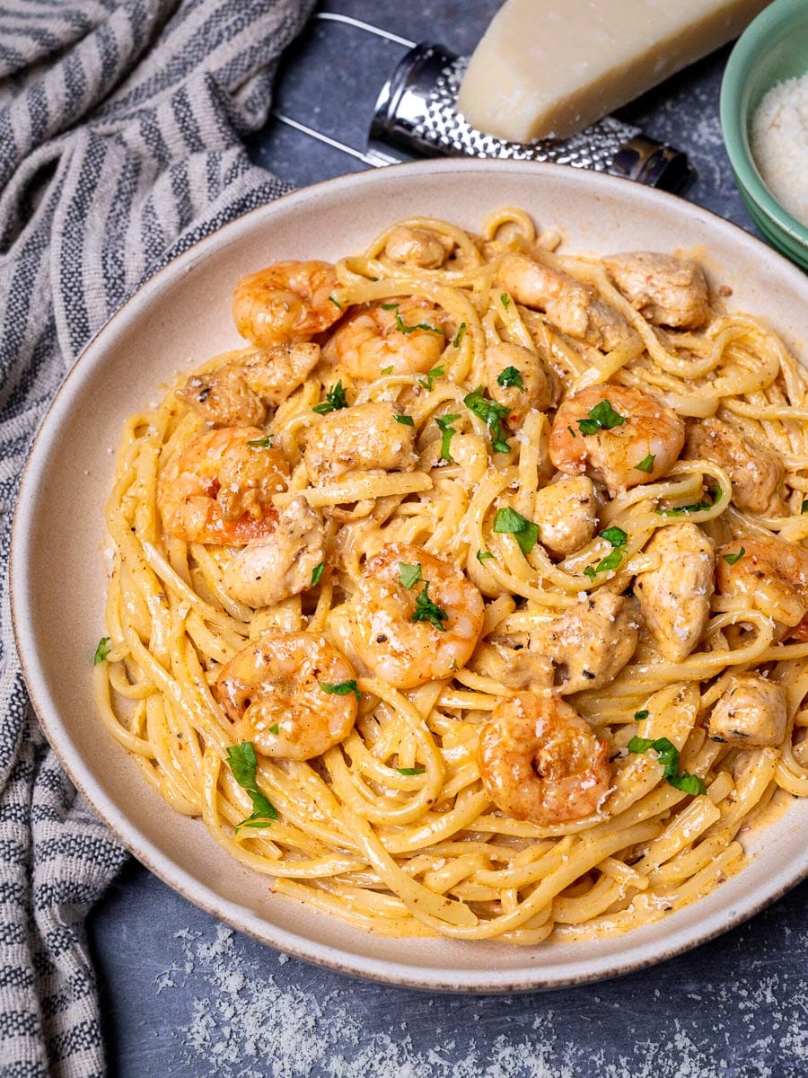 A bowl of linguine with chicken and prawns