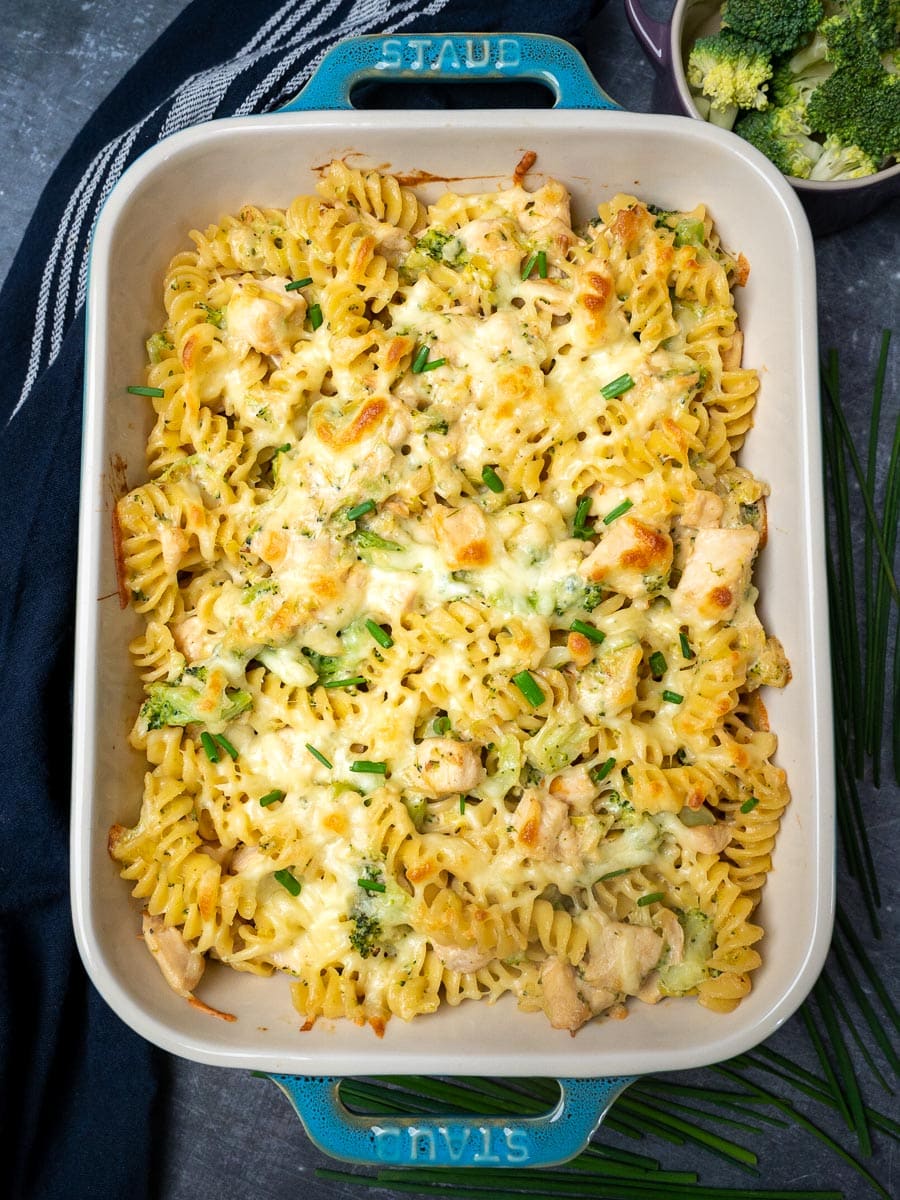 A chicken pasta casserole with broccoli on the side