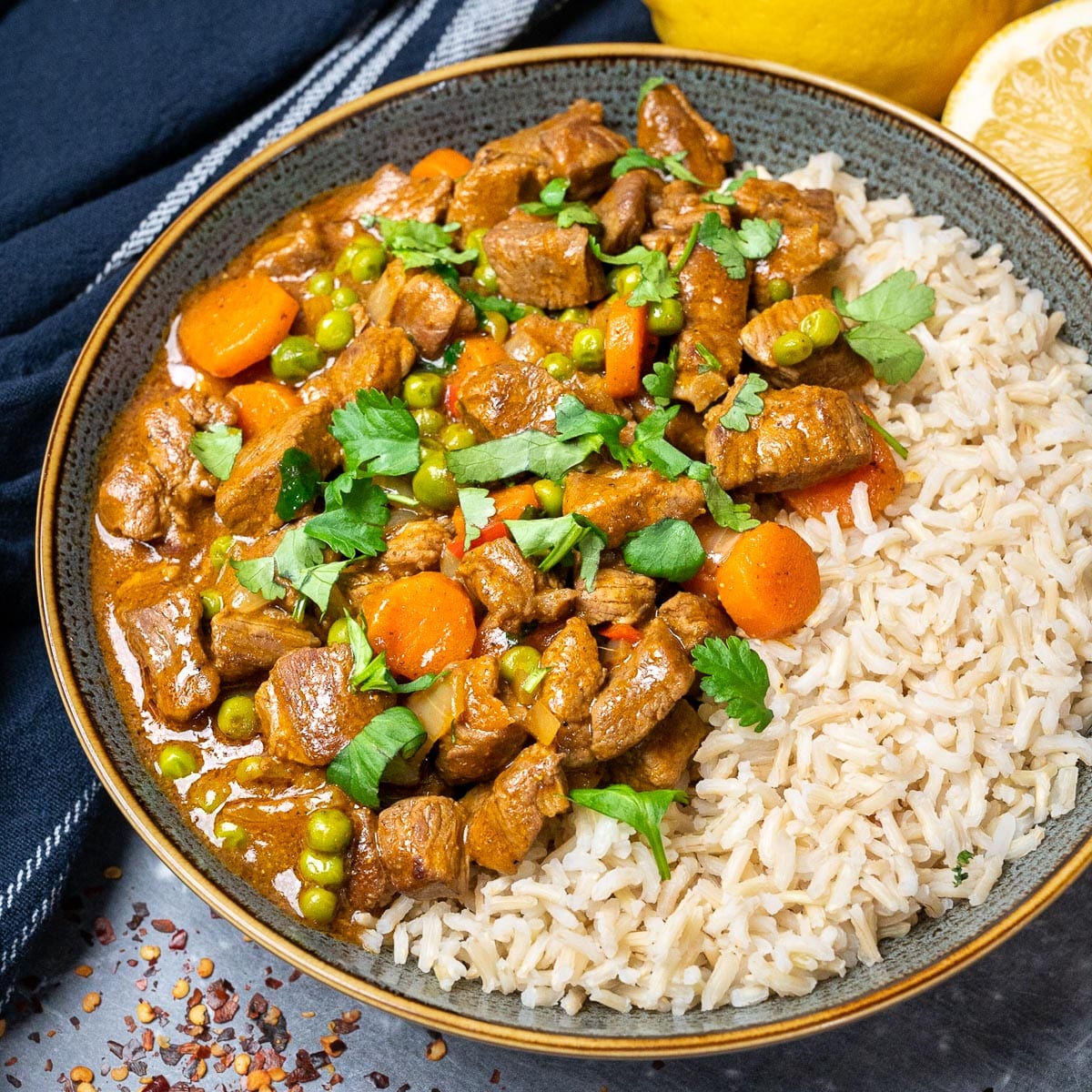 A bowl of curry with rice on the side
