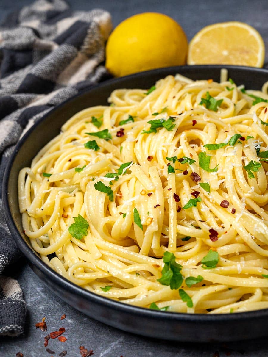Close up photo of a pasta dish with lemons on the side