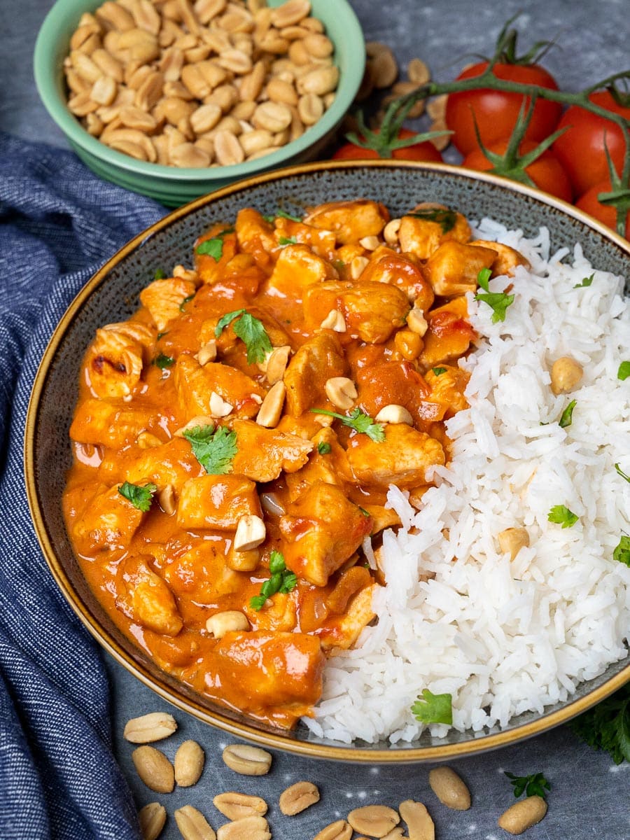 A bowl of curry with peanuts and chicken
