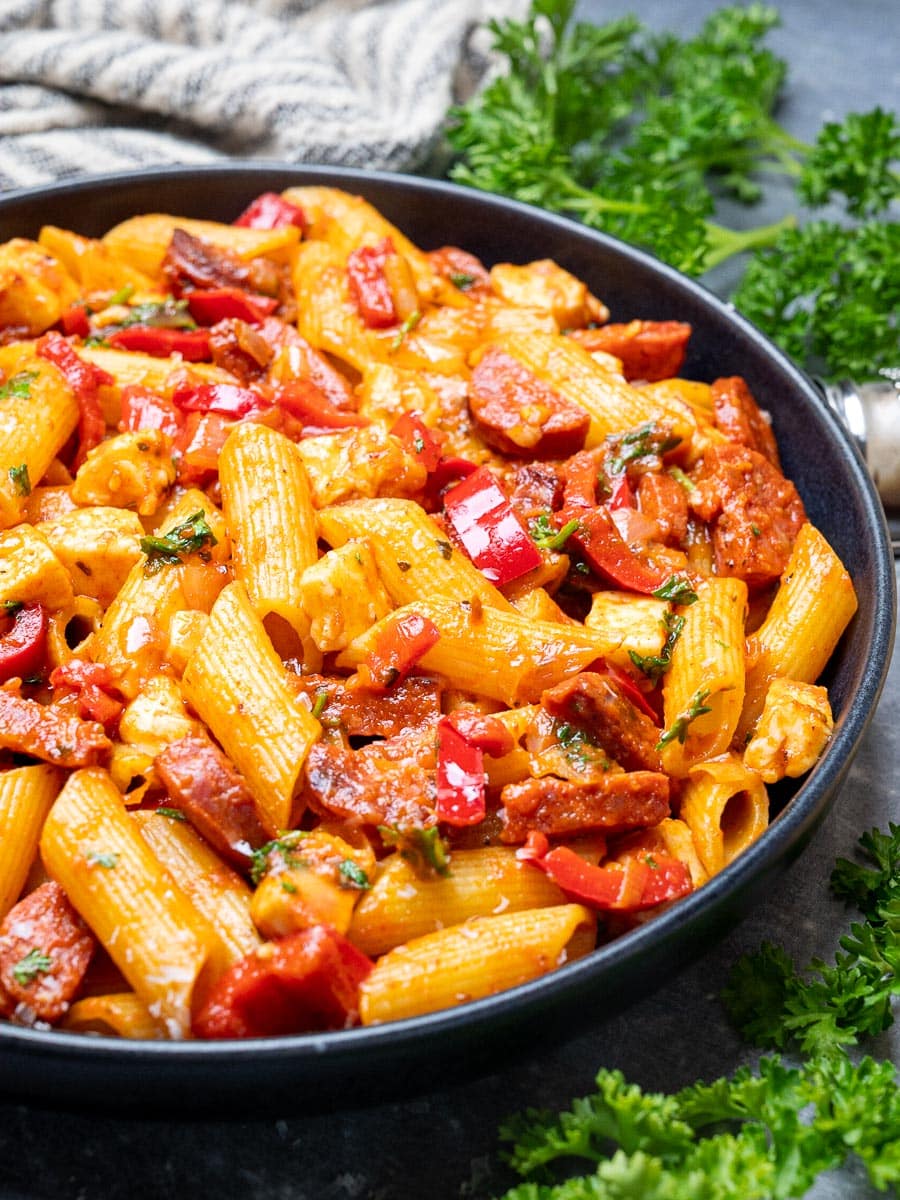 A bowl of pasta with sausage and cheese
