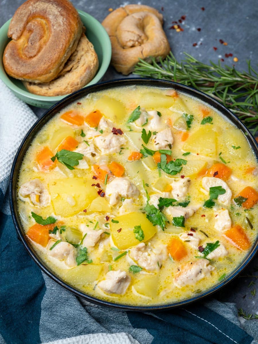 A bowl of soup with chicken and potatoes