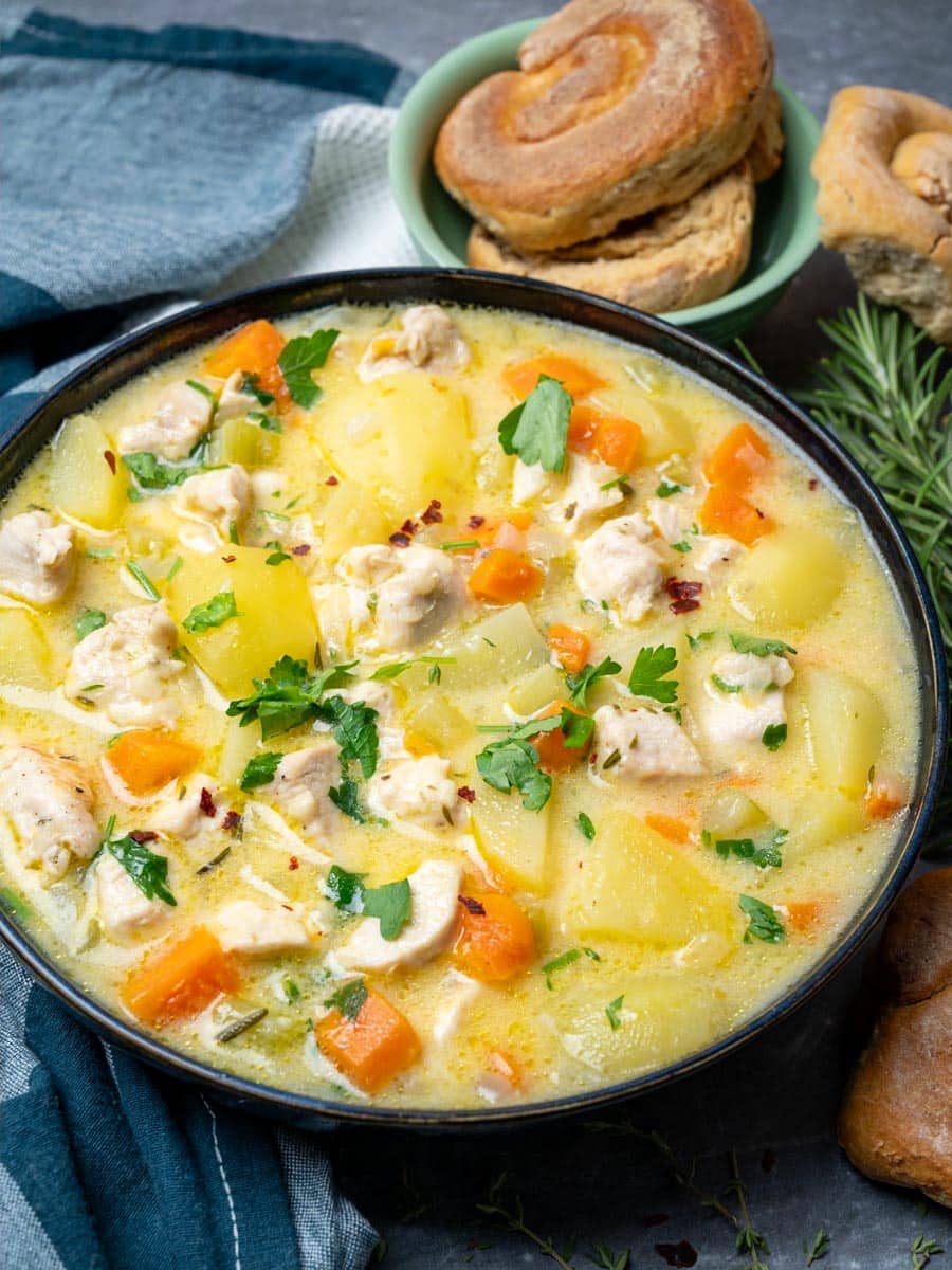 A bowl of creamy soup with chicken and potatoes