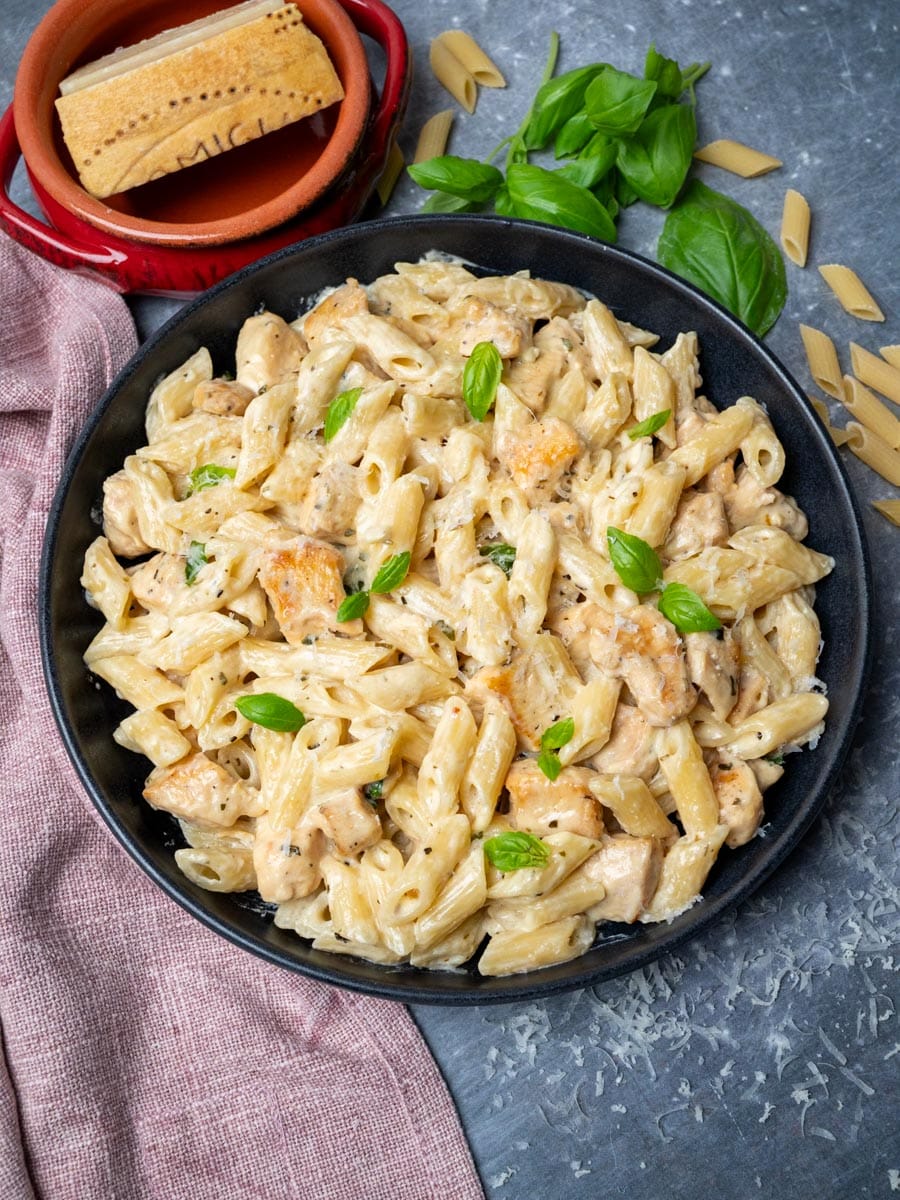 A bowl of pasta with chicken, garlic and parmesan