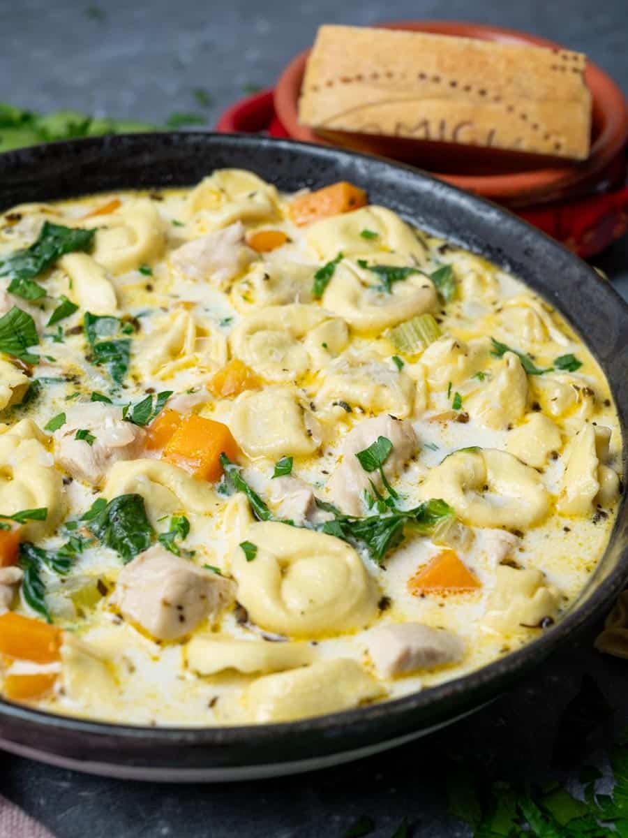 A close-up photo of a bowl of chicken alfredo tortellini soup