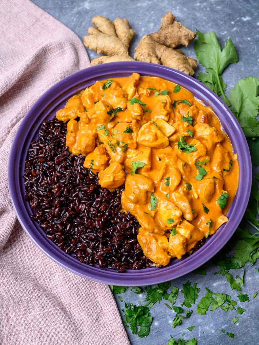 A bowl of Instant Pot butter chicken on black rice.