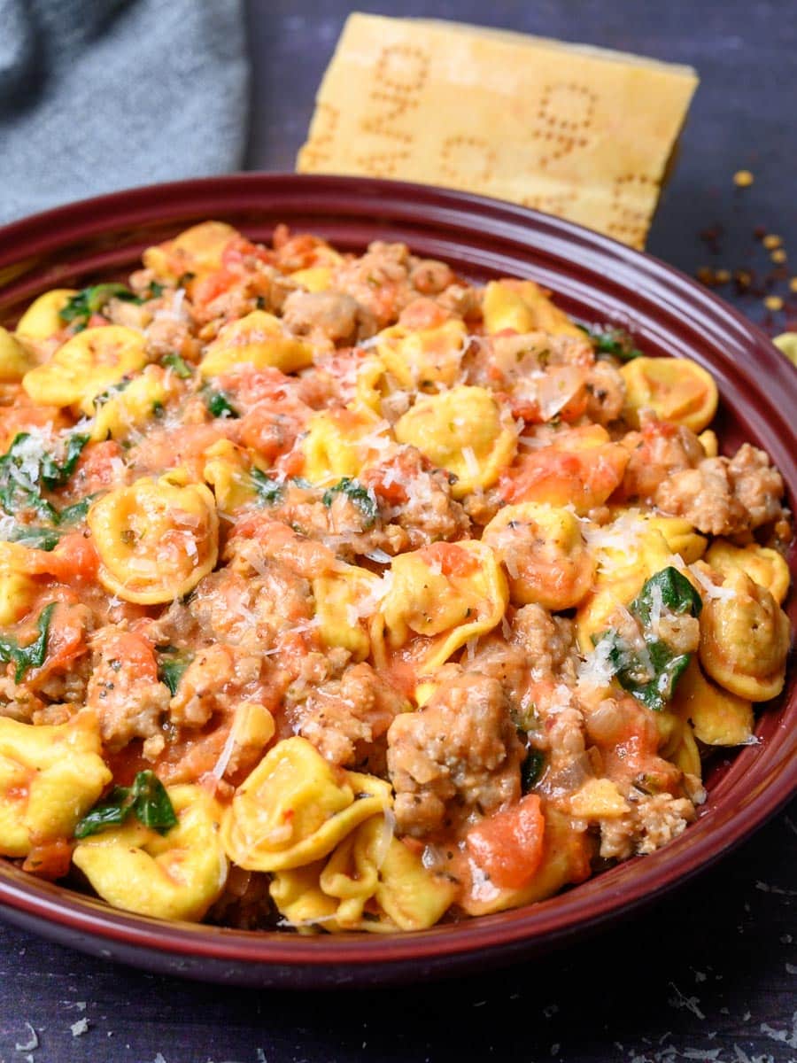 A close-up photo of a bowl of pasta with sausage.