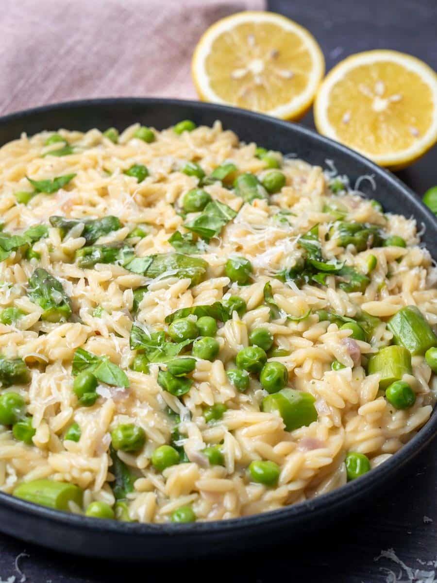 A close-up photo of a bowl of orzo with spring greens