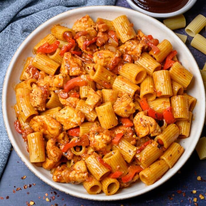 A bowl of pasta with chicken, peppers, and BBQ sauce