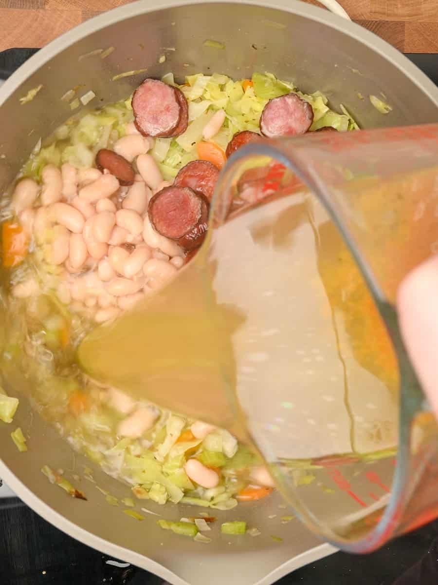 adding stock to a Cabbage Sausage Soup