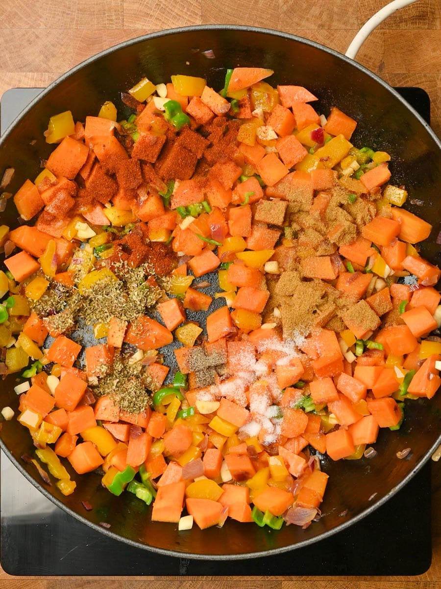 adding spices to a black bean casserole