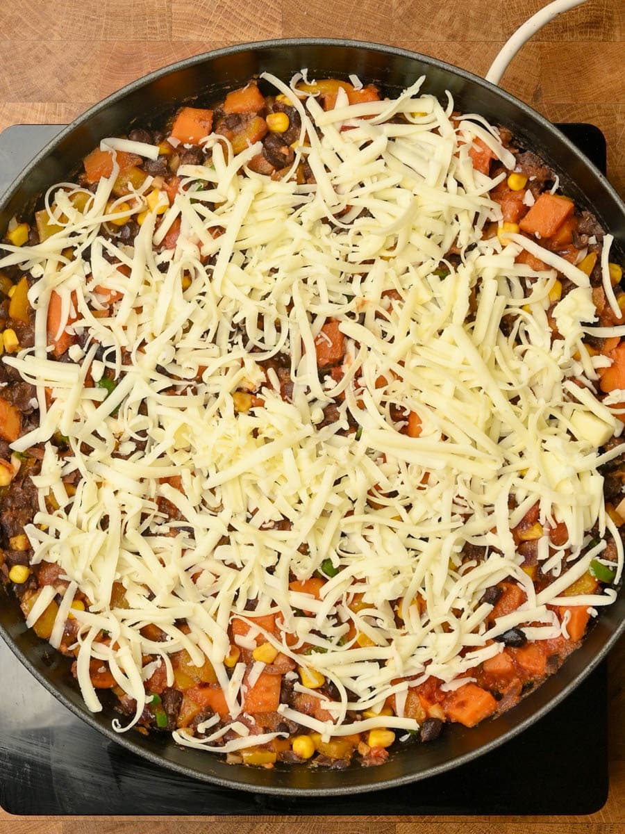 adding cheese to a Mexican dish