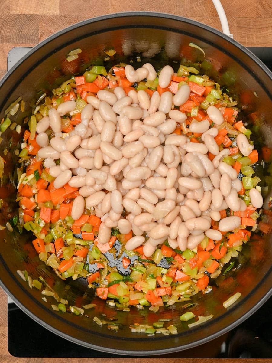 adding beans to a chicken parmesan soup