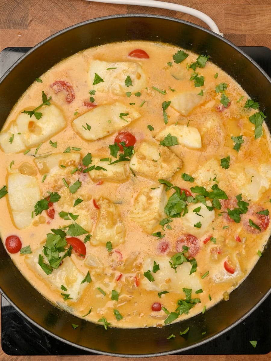 Creamy white fish chunks simmered in golden curry sauce with cherry tomatoes and coriander