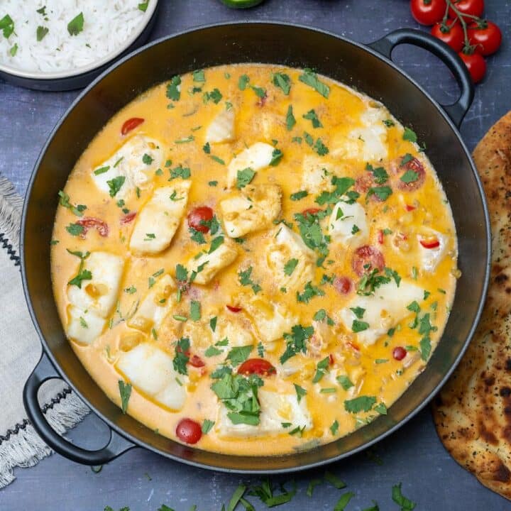 Easy coconut fish curry topped with cherry tomatoes and coriander, served with warm naan on the side