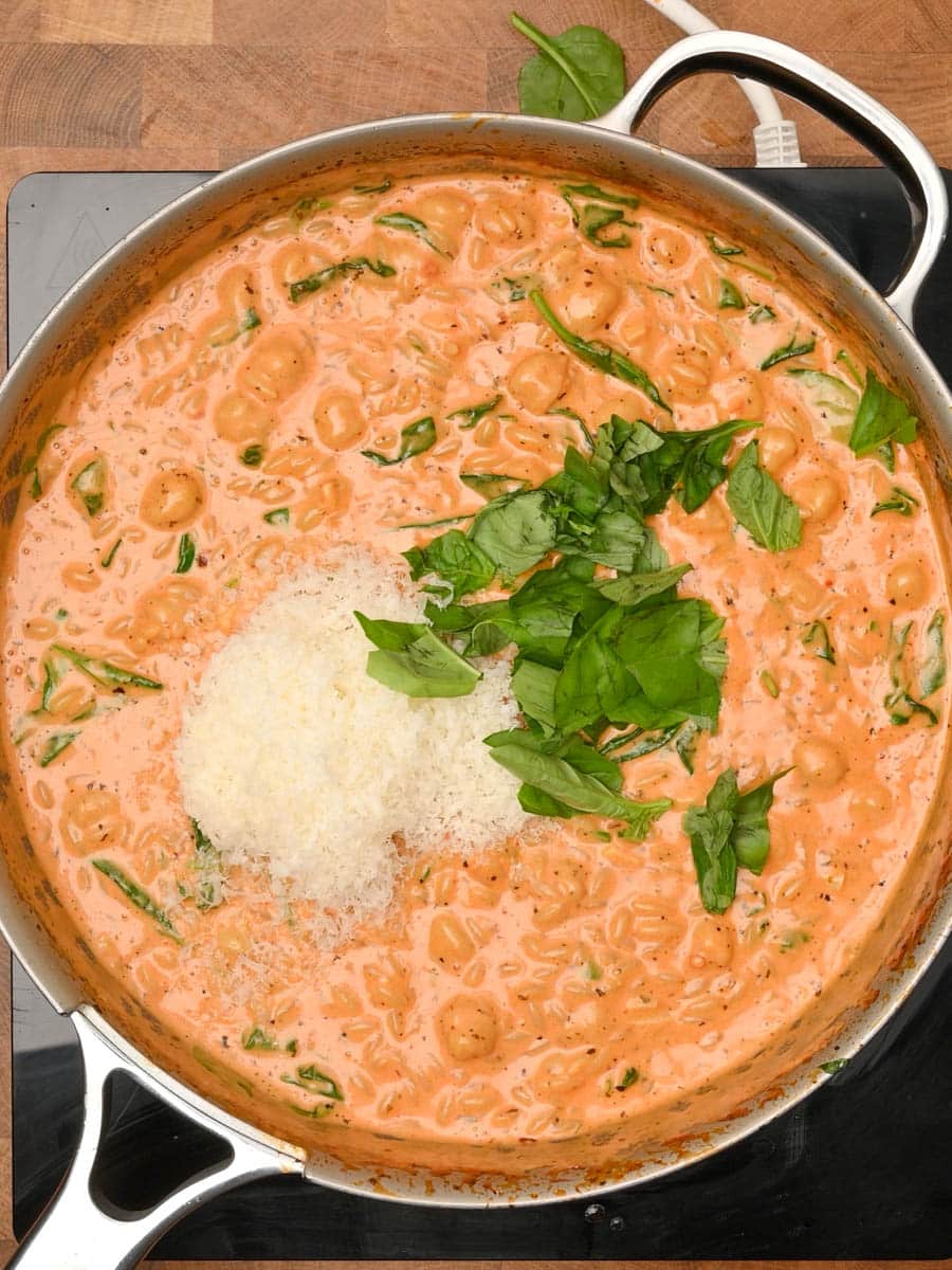 adding parmesan to a pasta dish