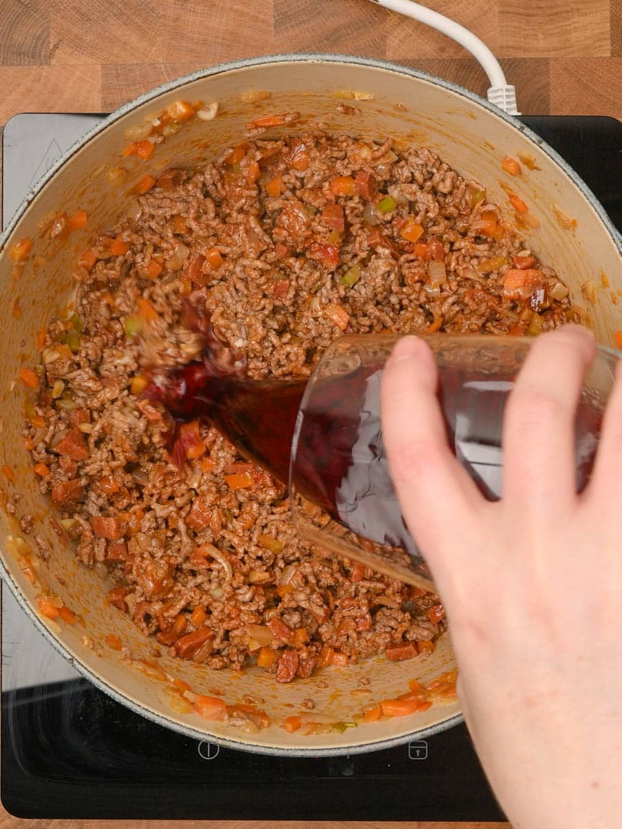 adding wine to a chorizo bolognese