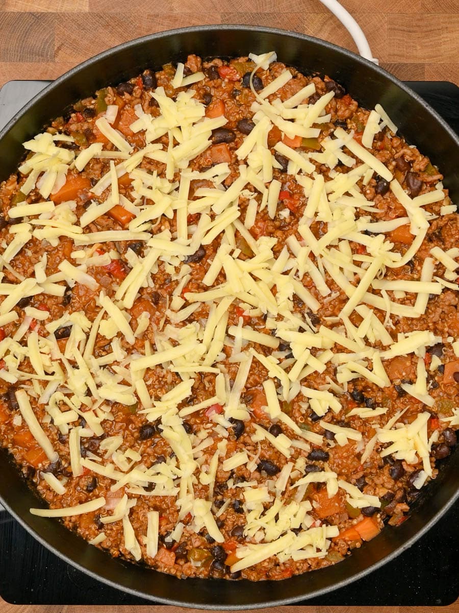Topping the Mexican ground beef skillet with grated cheddar cheese