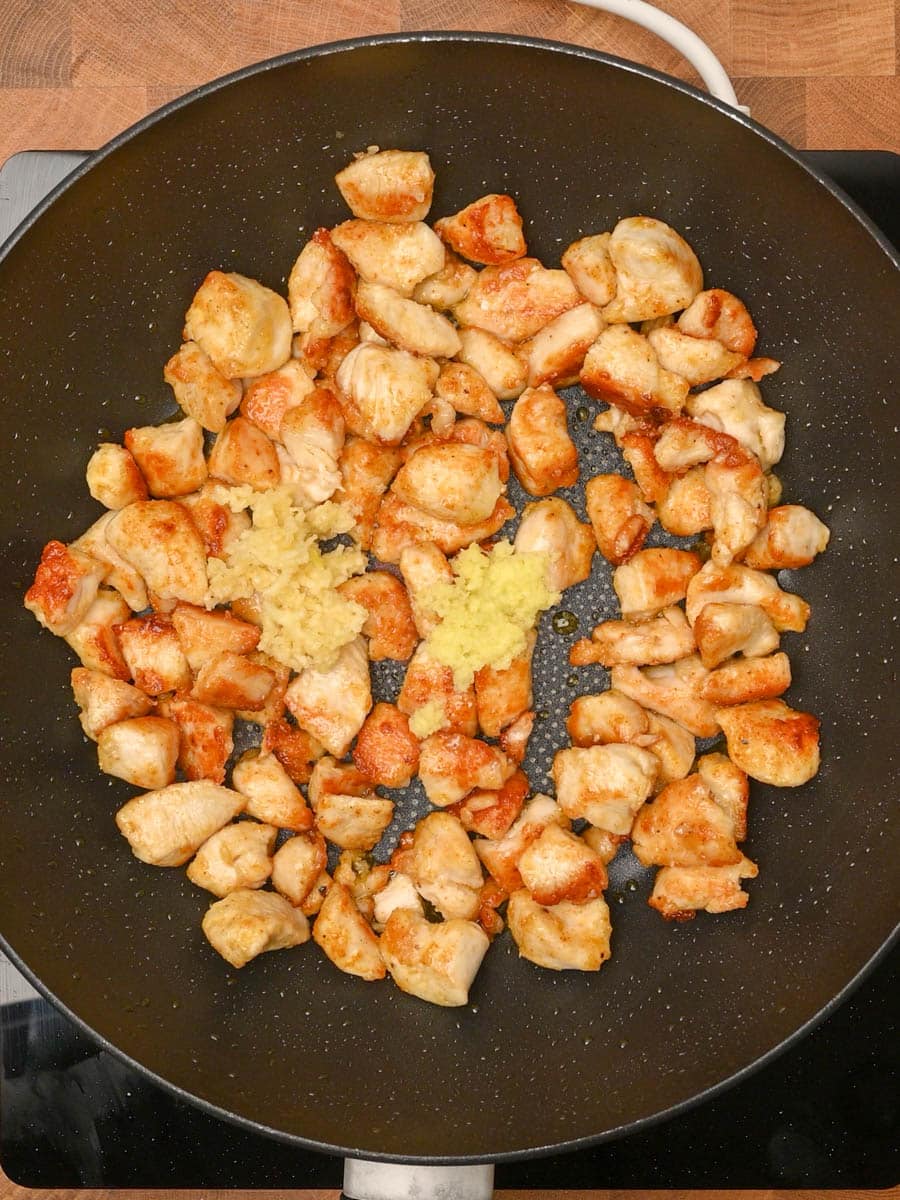 adding garlic to a crispy sweet chilli chicken