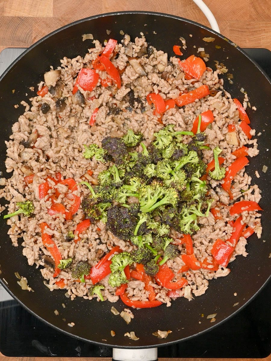 adding broccoli to a Chinese dish