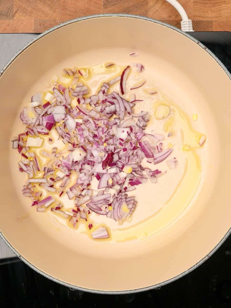 adding onions to a spicy tuna pasta