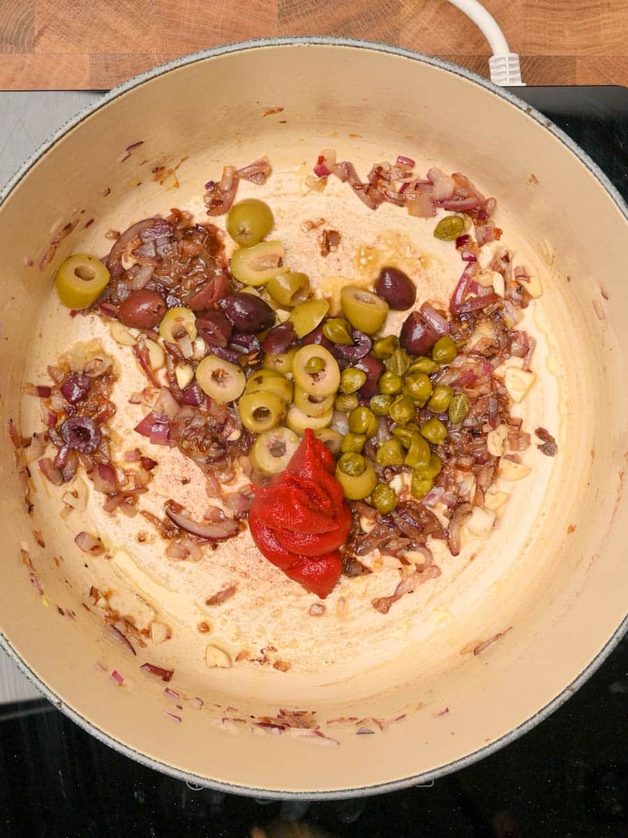adding olives to an Italian dish
