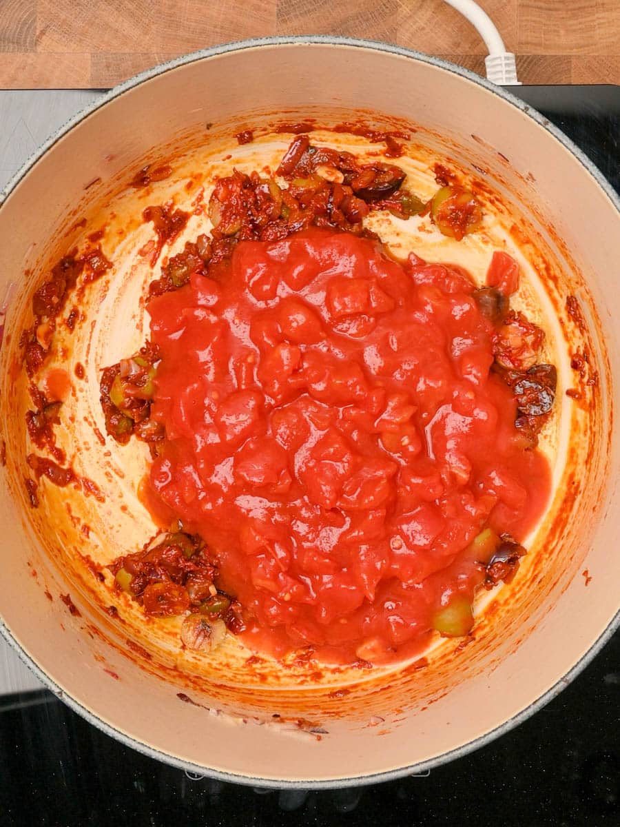 adding chopped tomatoes to an Italian dish