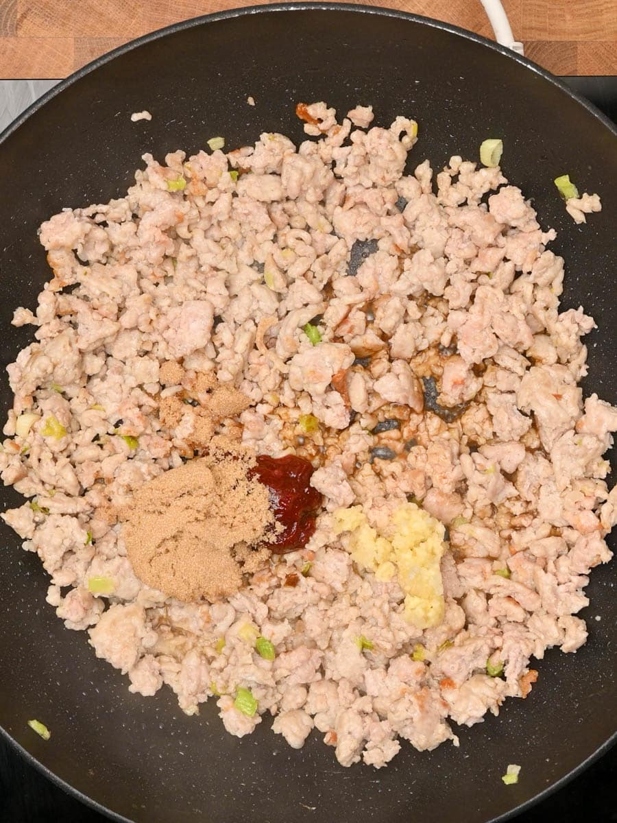 adding spices to peanut chicken noodles