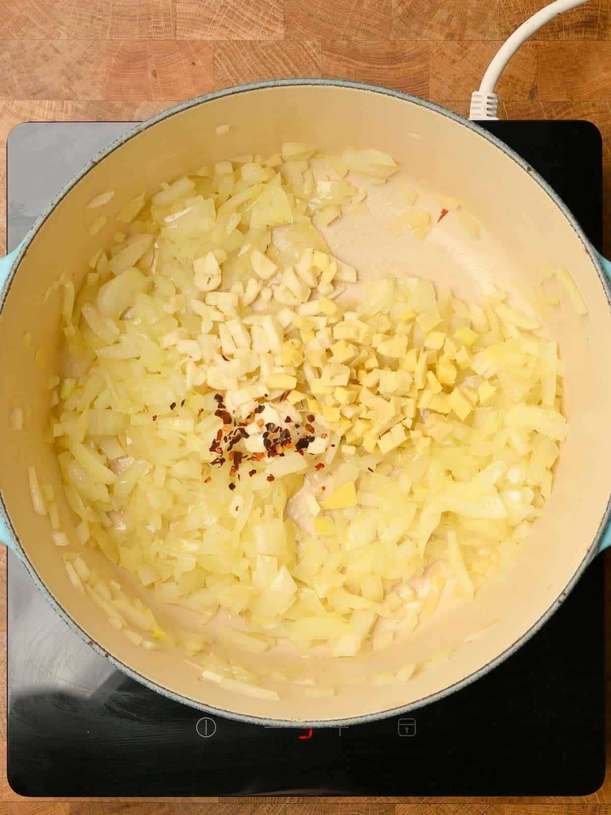 Sautéing garlic, ginger and onions in a pot.