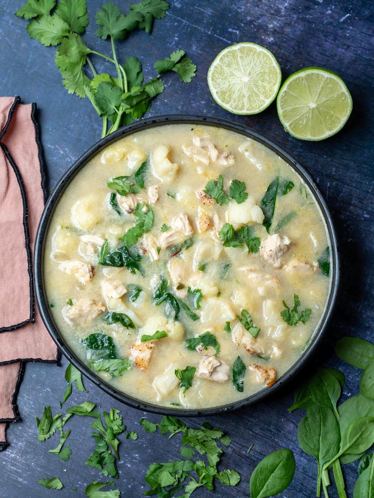 A black bowl with cauliflower chicken soup.
