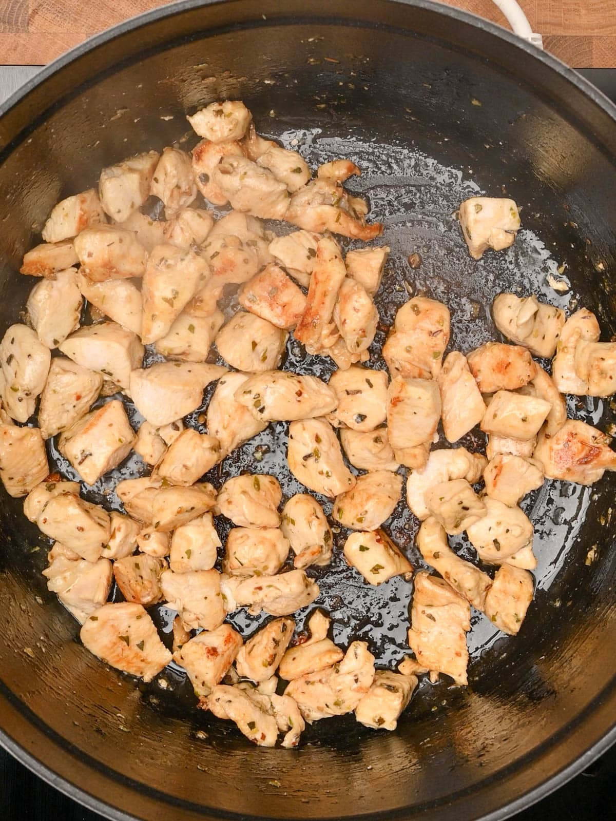 Frying chicken in a black pot.