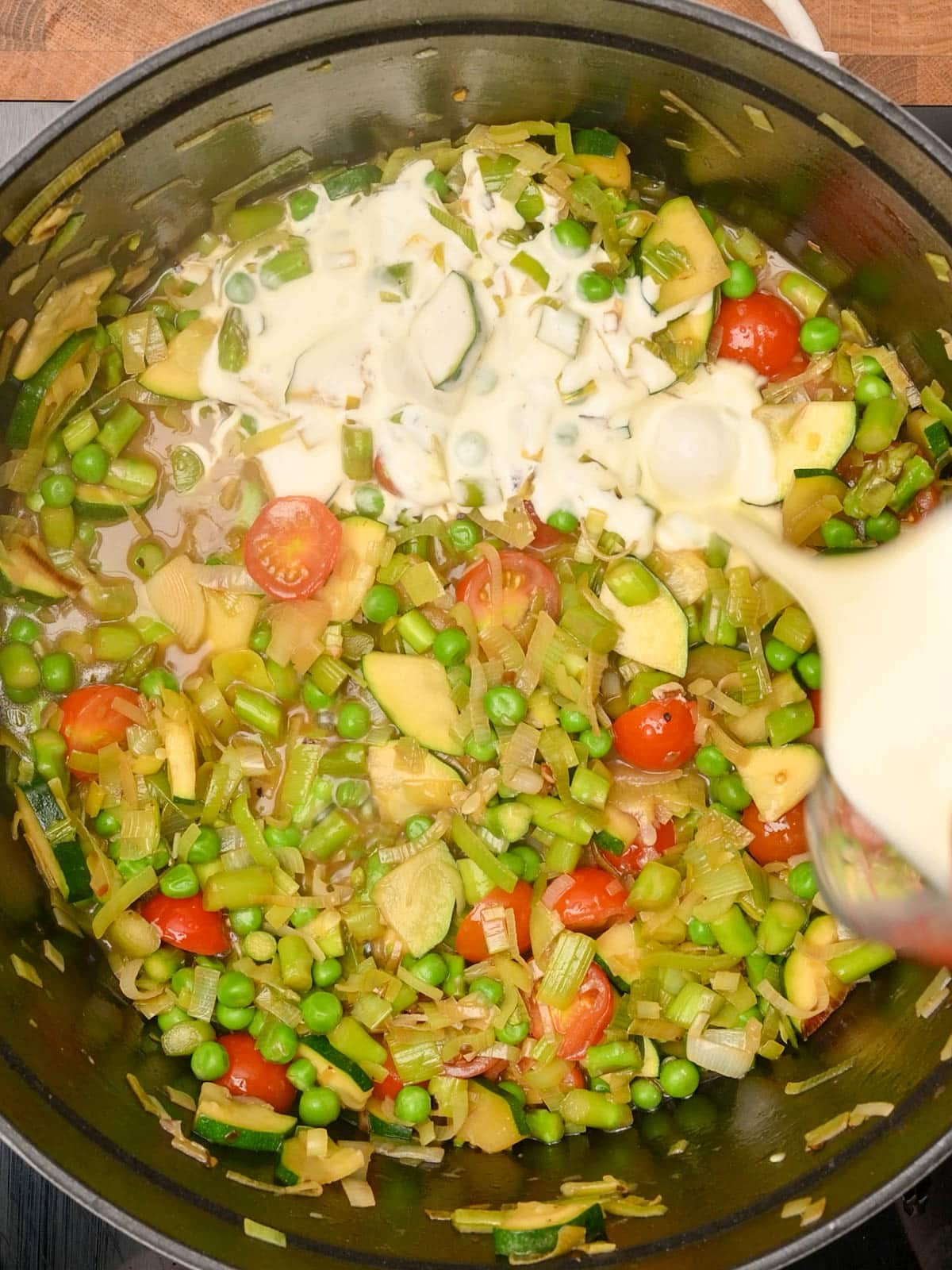 pouring heavy cream to Chicken Pasta Primavera