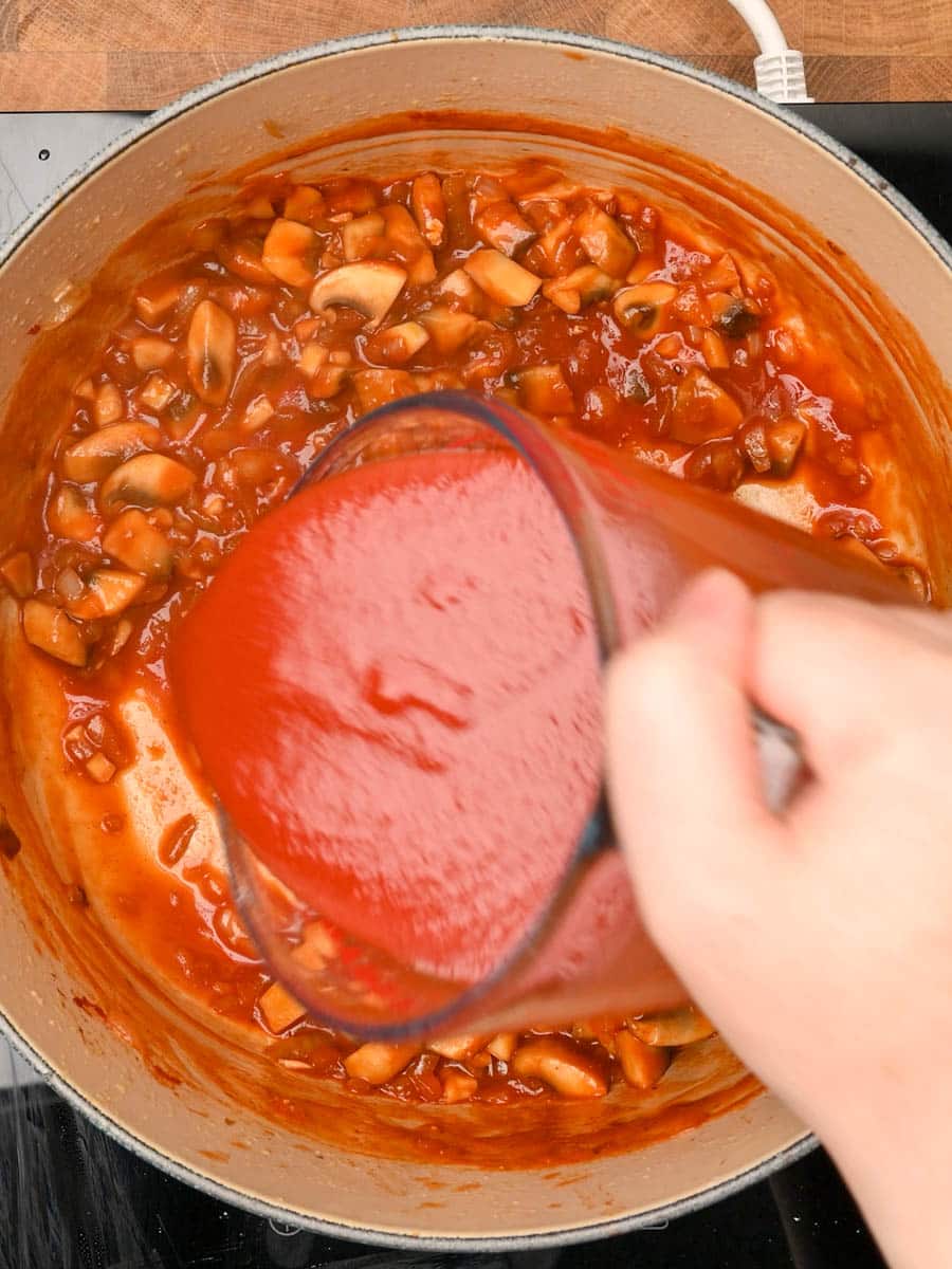 adding passata to a chicken pasta bake