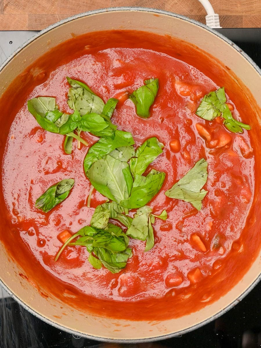 adding basil to a chicken pasta bake