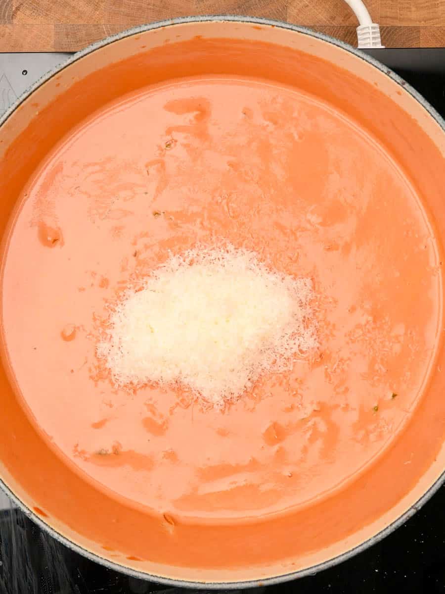 adding parmesan to a chicken pasta bake