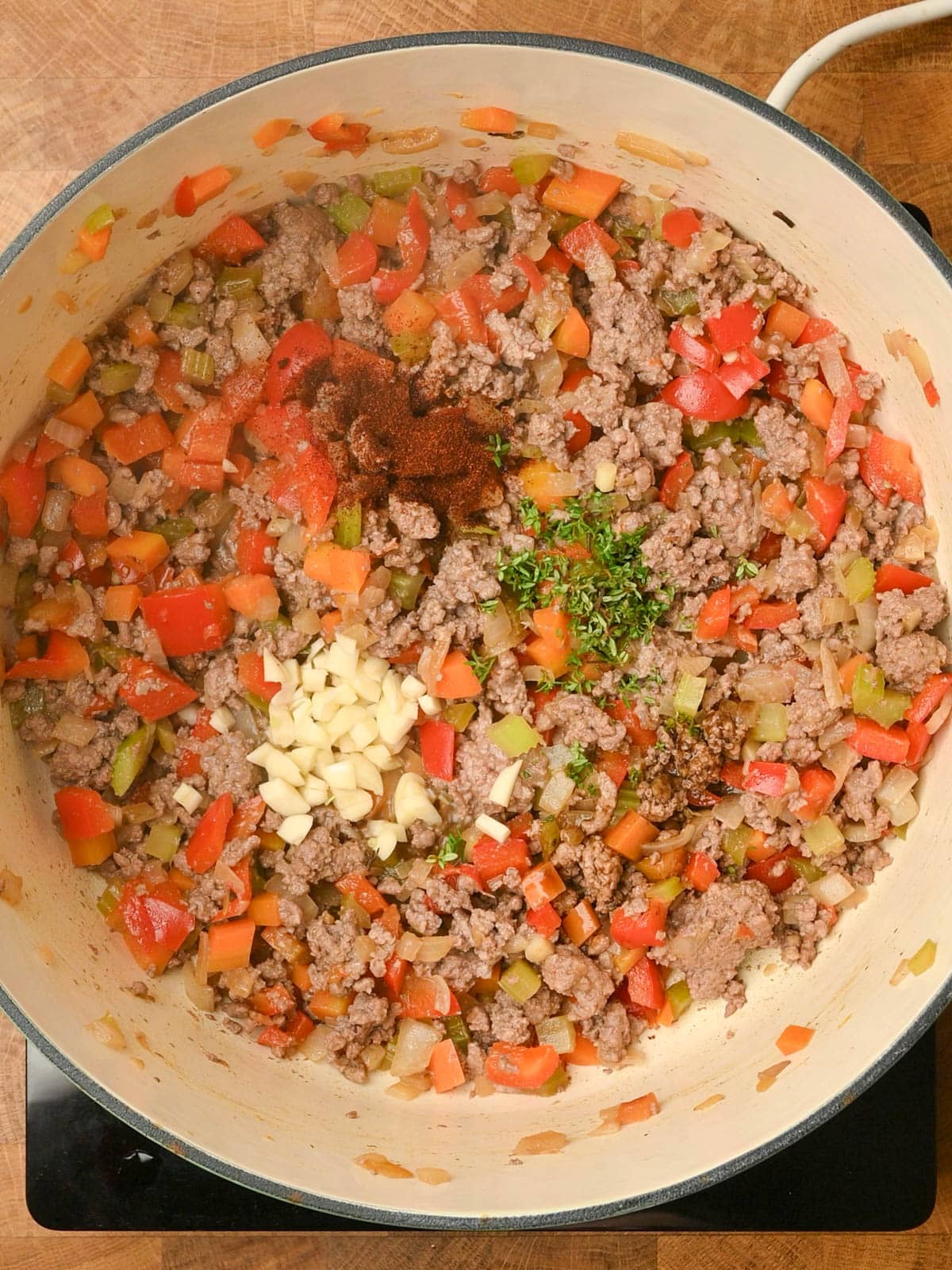 adding spices to a ground beef stew