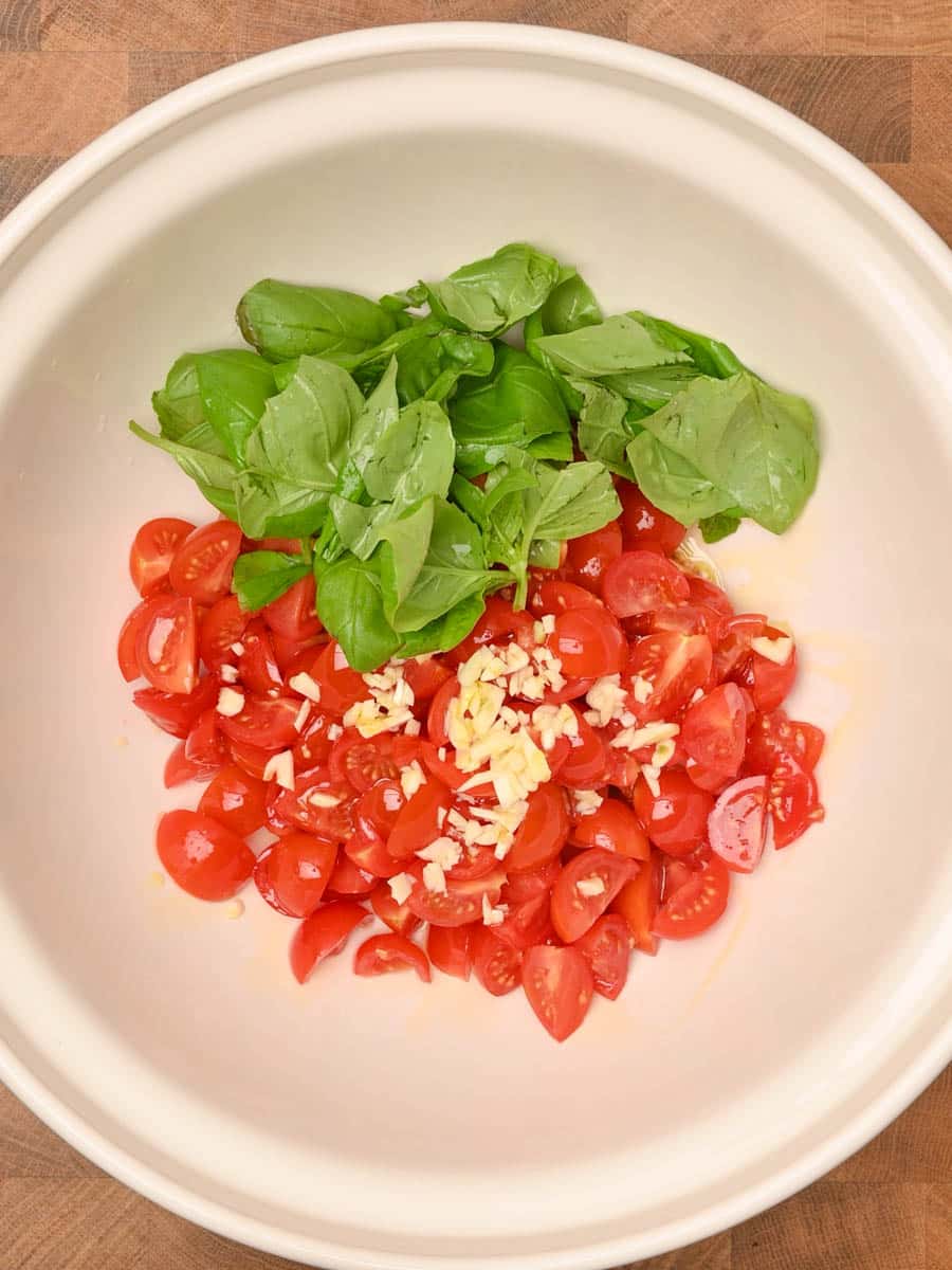 Stirring in the basil and garlic to make fresh tomato and basil pasta