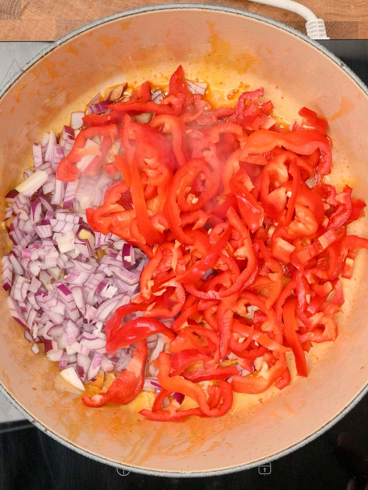 adding peppers and onion to the pot