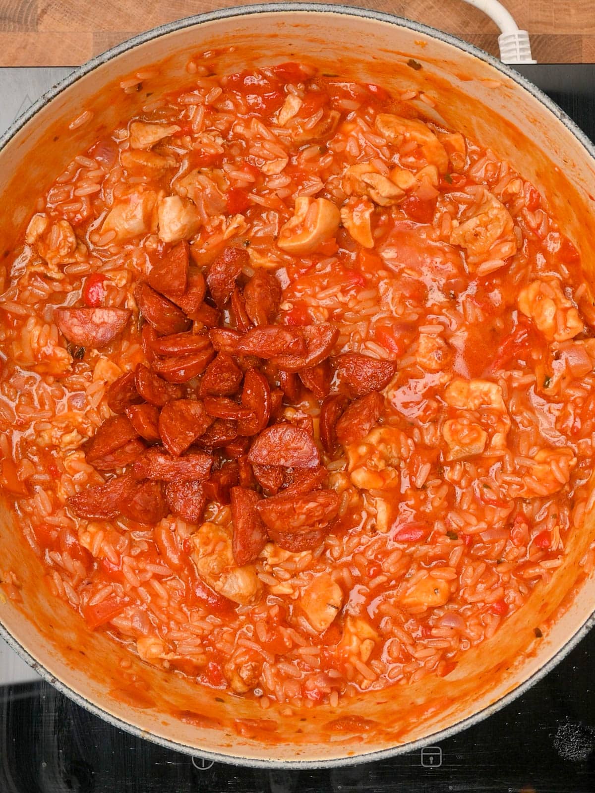 adding the sausage to the pot