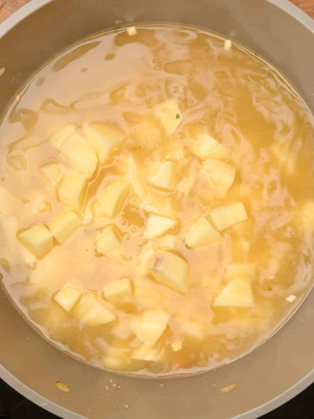 adding stock to the cooking pot