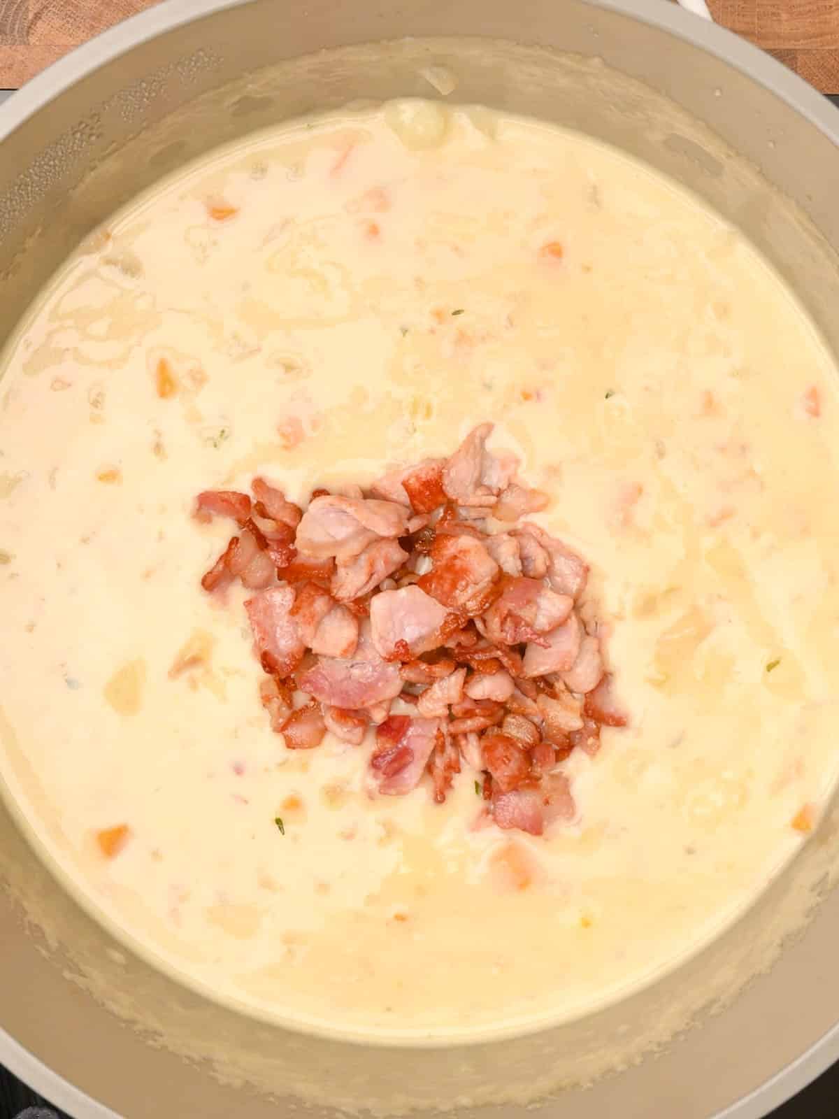 adding bacon to the cooking pot