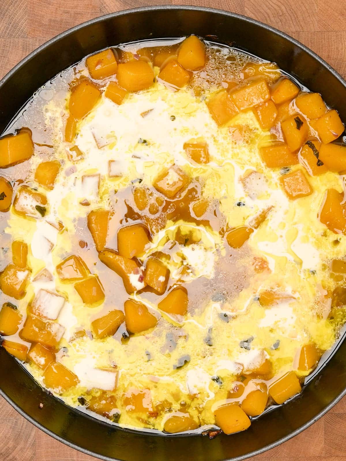 pouring stock and cream to butternut squash gnocchi
