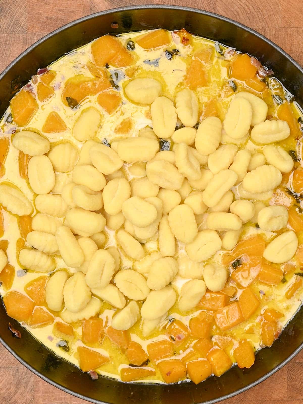 adding gnocchi to the cooking pan