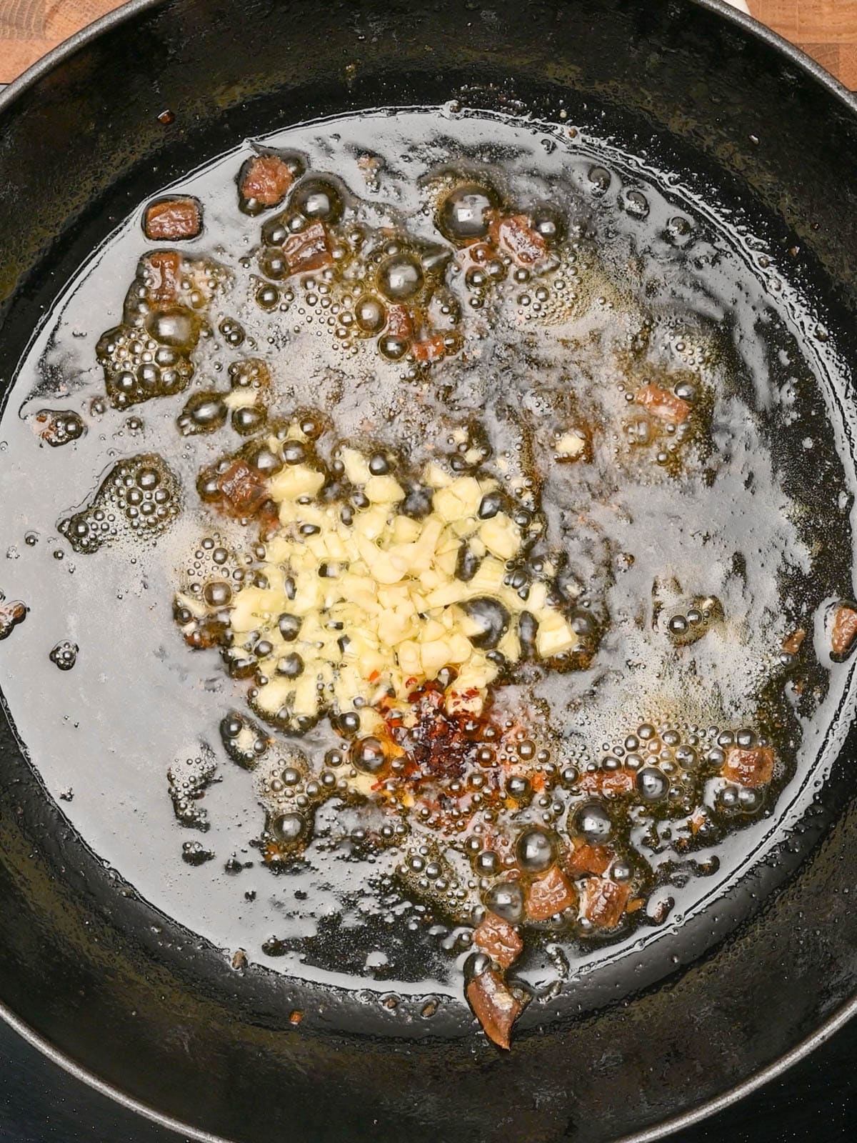 adding garlic to chicken puttanesca