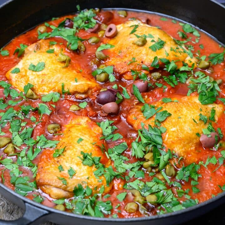 close up photo of pieces of chicken thighs with parsley on top